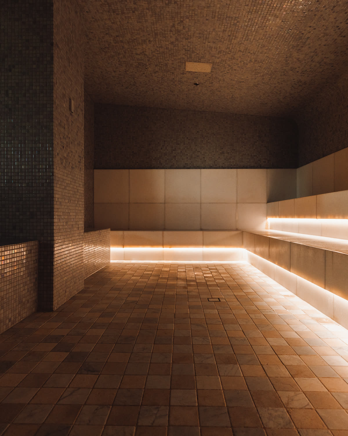The tiled EQ steam room, empty and lit low