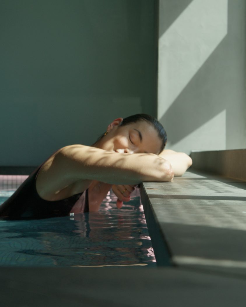 A guest resting her head on the edge of the mineral pool