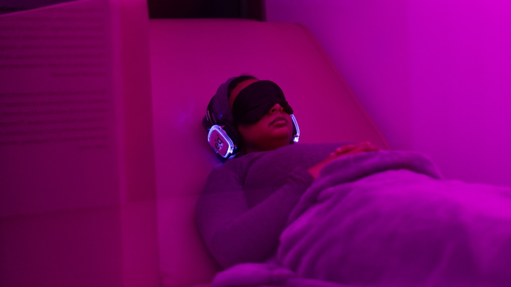 A guest in the breathwork lounge wearing an eye mask and headphones